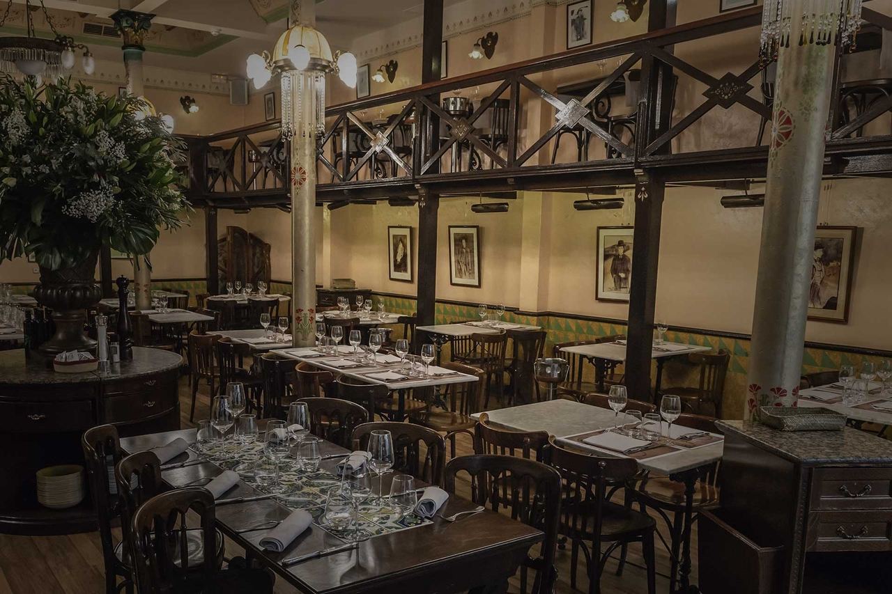 The dining room at Els Quatre Gats under its timber gallery and Modernista columns