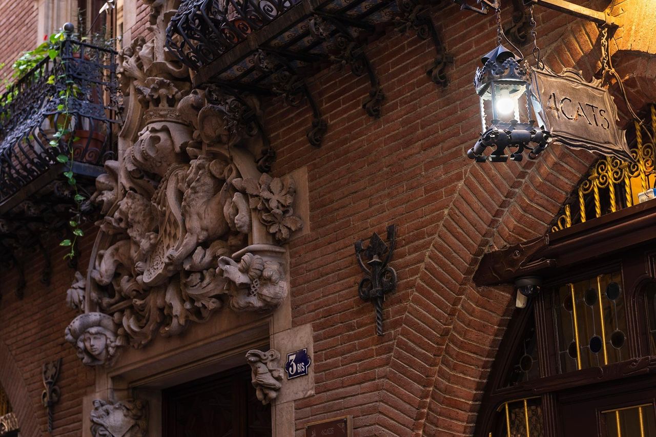 The carved stone doorway and wrought-iron lantern of Els Quatre Gats in Casa Martí