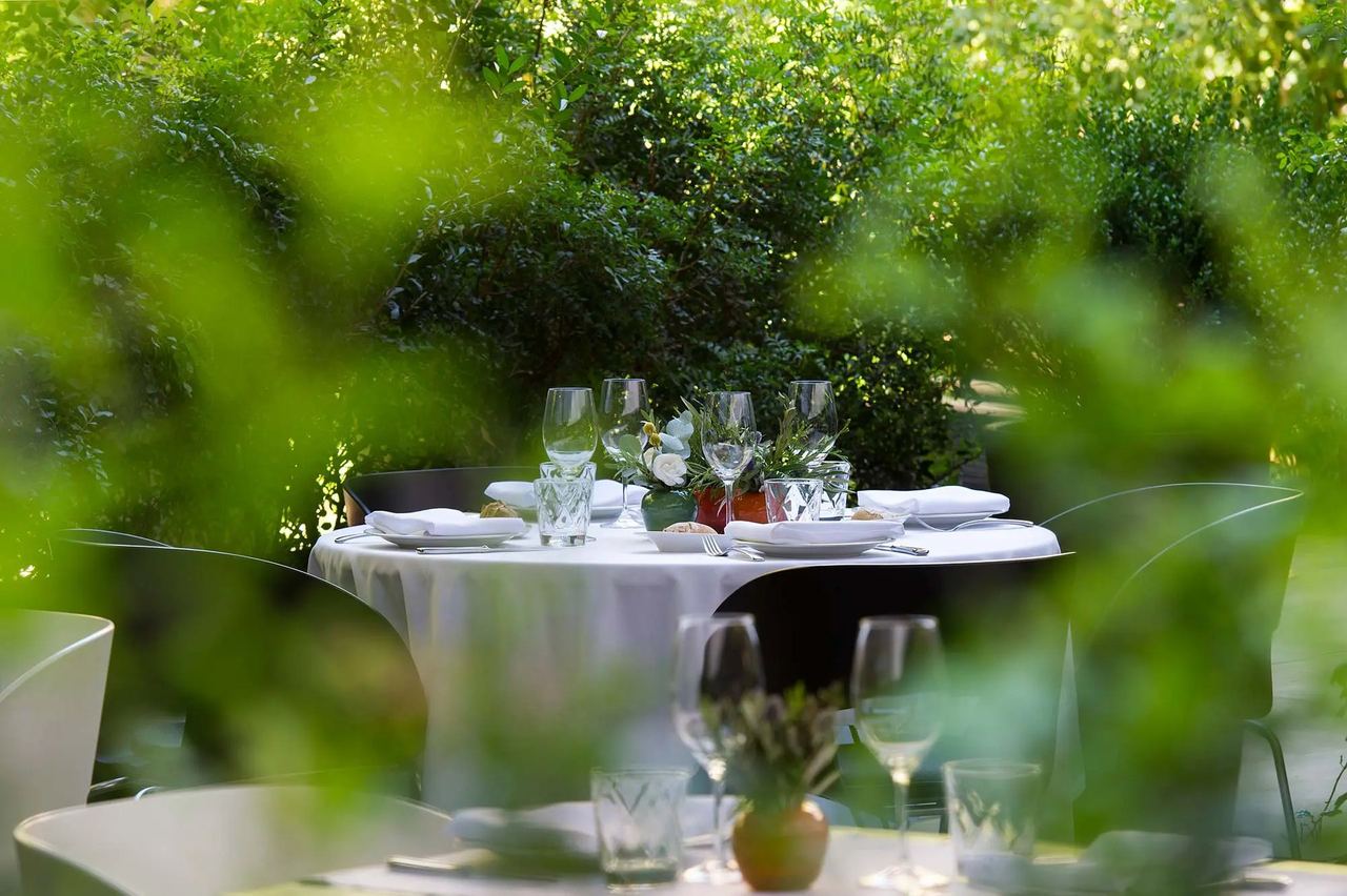 A table laid for dinner among the greenery of the garden at Alma Barcelona