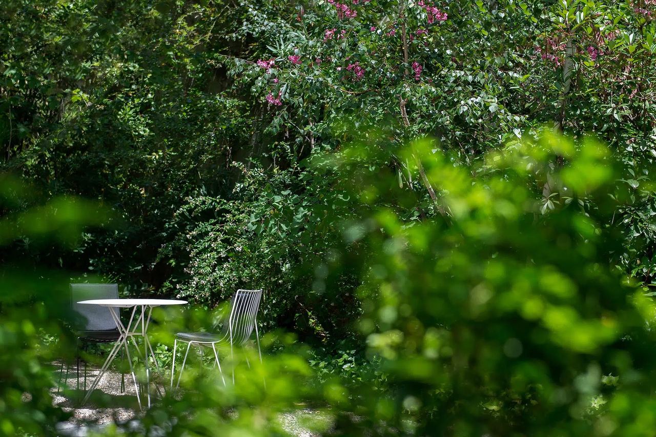 A table and chairs in the leafy garden at Alma Barcelona