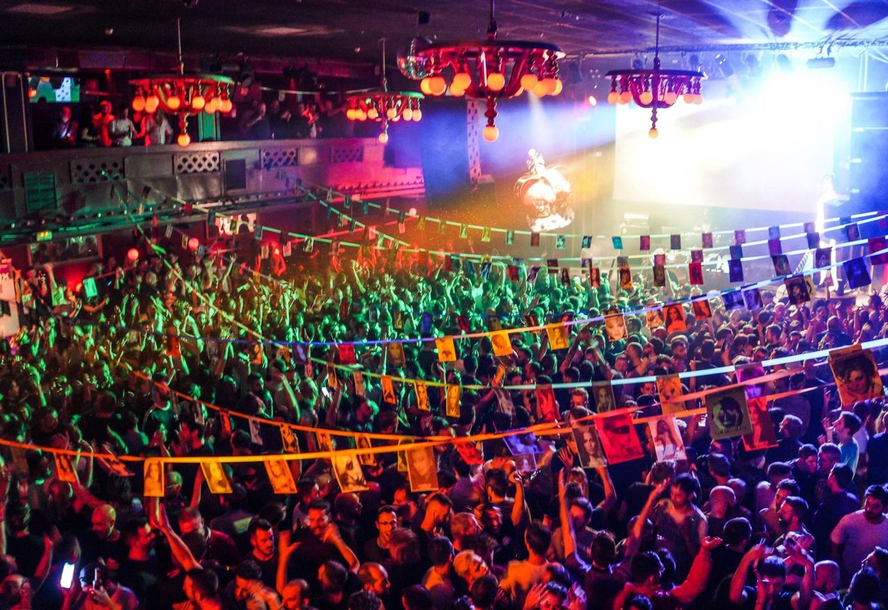 A packed club night in the old ballroom at Sala Apolo, under red chandeliers and bunting