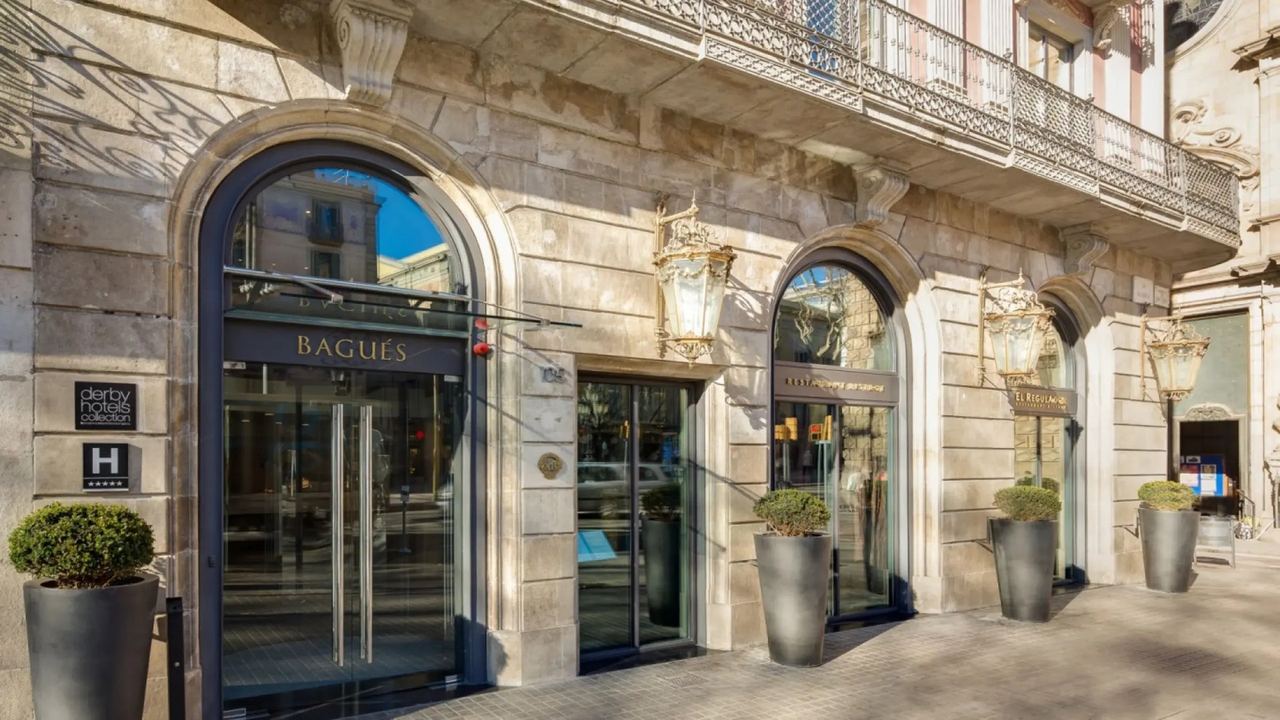 The arched stone entrance of Hotel Bagués on La Rambla, with brass lanterns