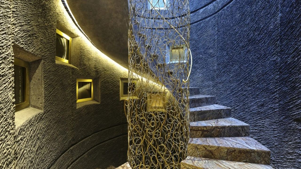 The spiral stone stair at Hotel Bagués, wrapped round a gilded wire screen