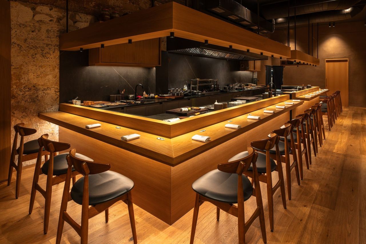 The long oak counter and stools wrapped around the open kitchen at Direkte