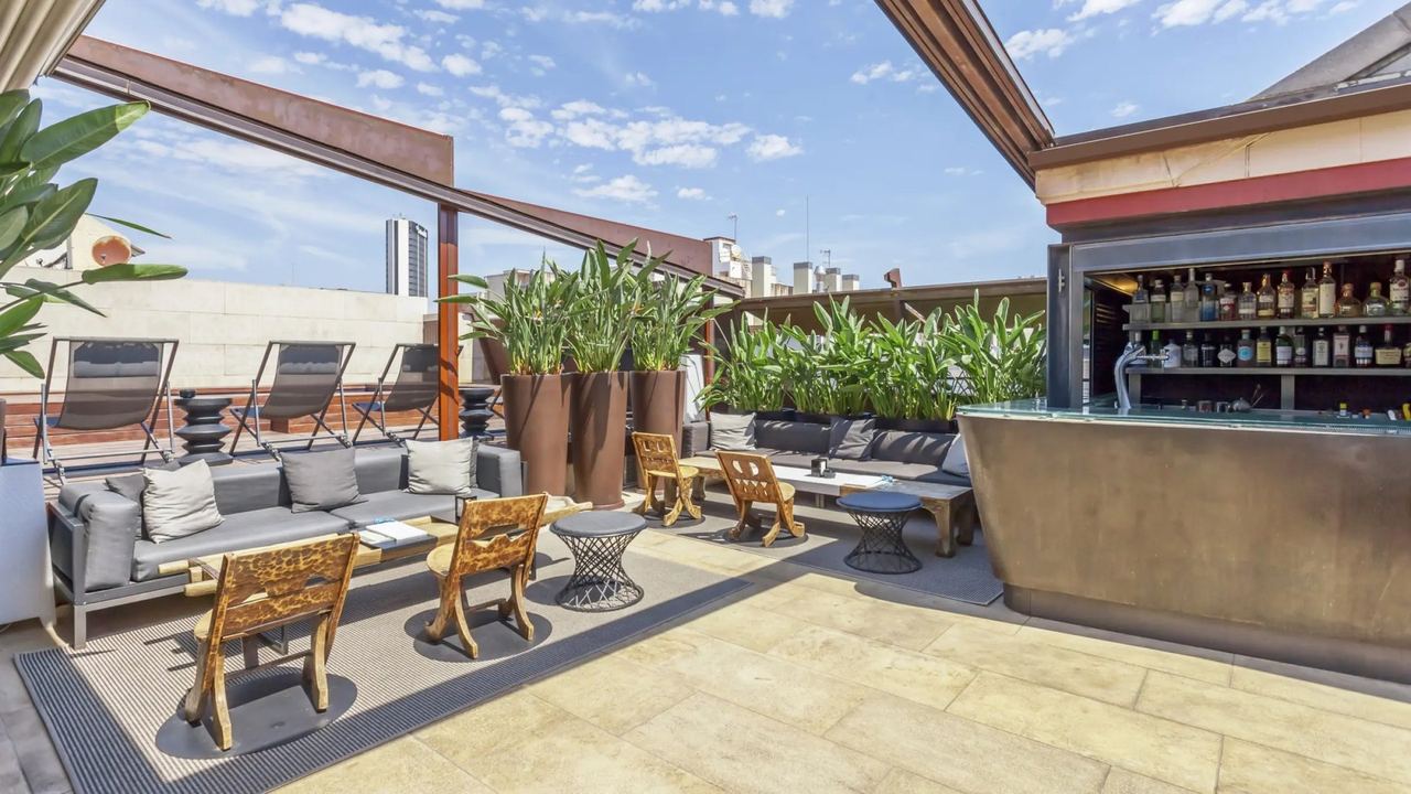The sunny roof terrace and bar at Granados 83, with loungers and planted pots