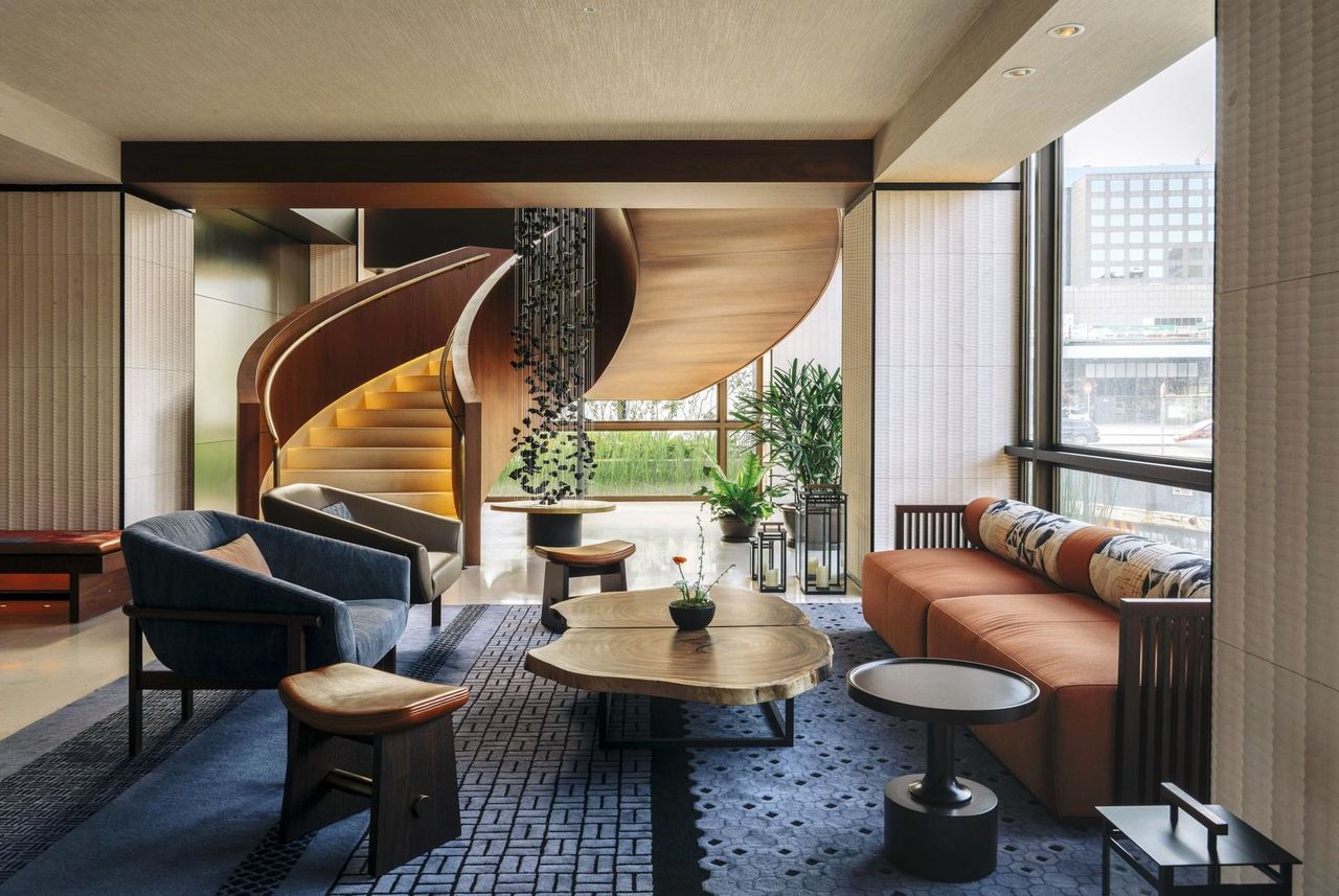 The lobby lounge at Nobu Hotel Barcelona, a timber spiral stair rising behind low armchairs